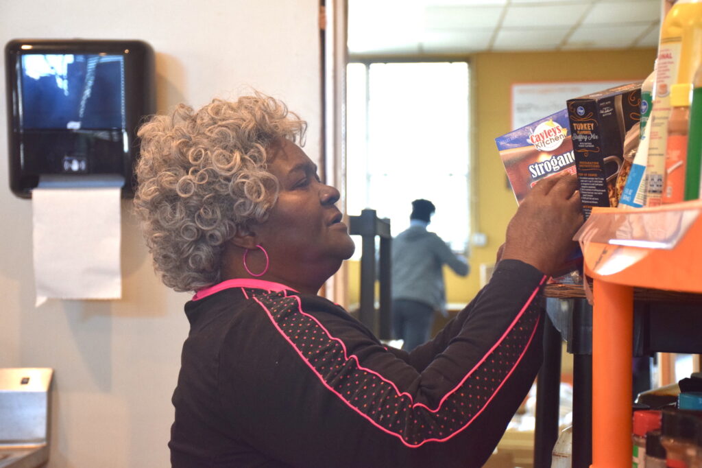 Mary peruses the kitchen shelves at The Little Pantry That Could