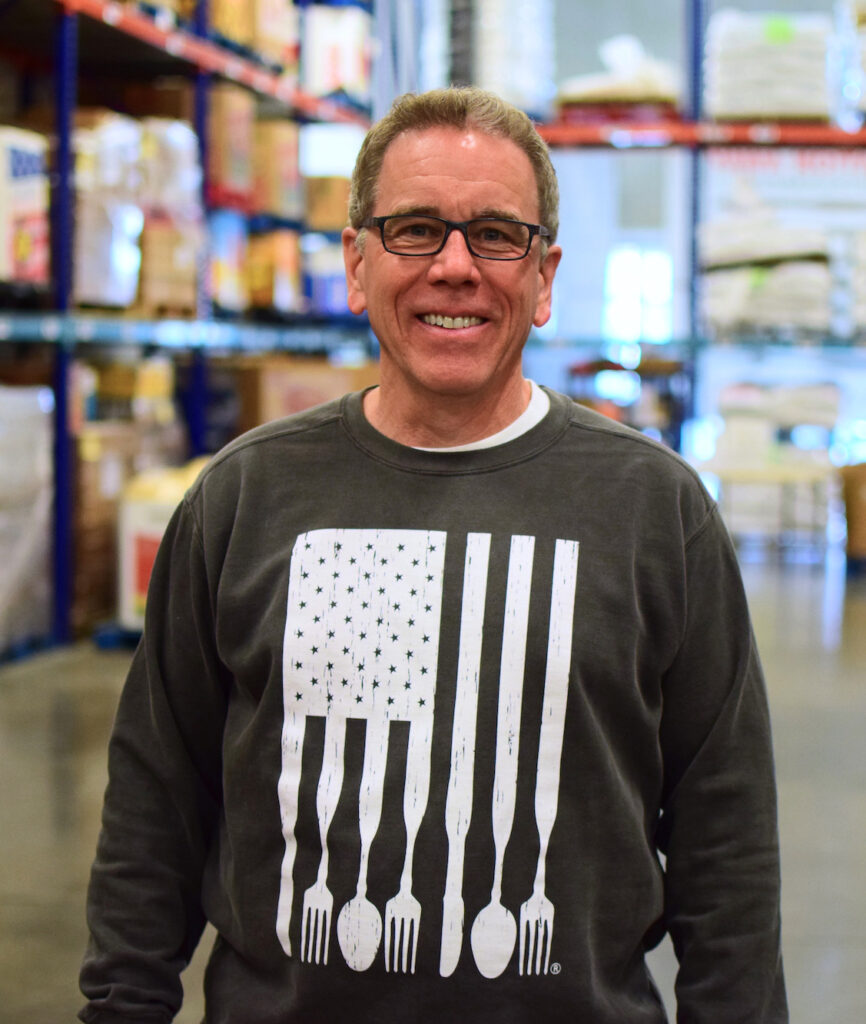 Chris Whitney stands in the OneGenAway warehouse