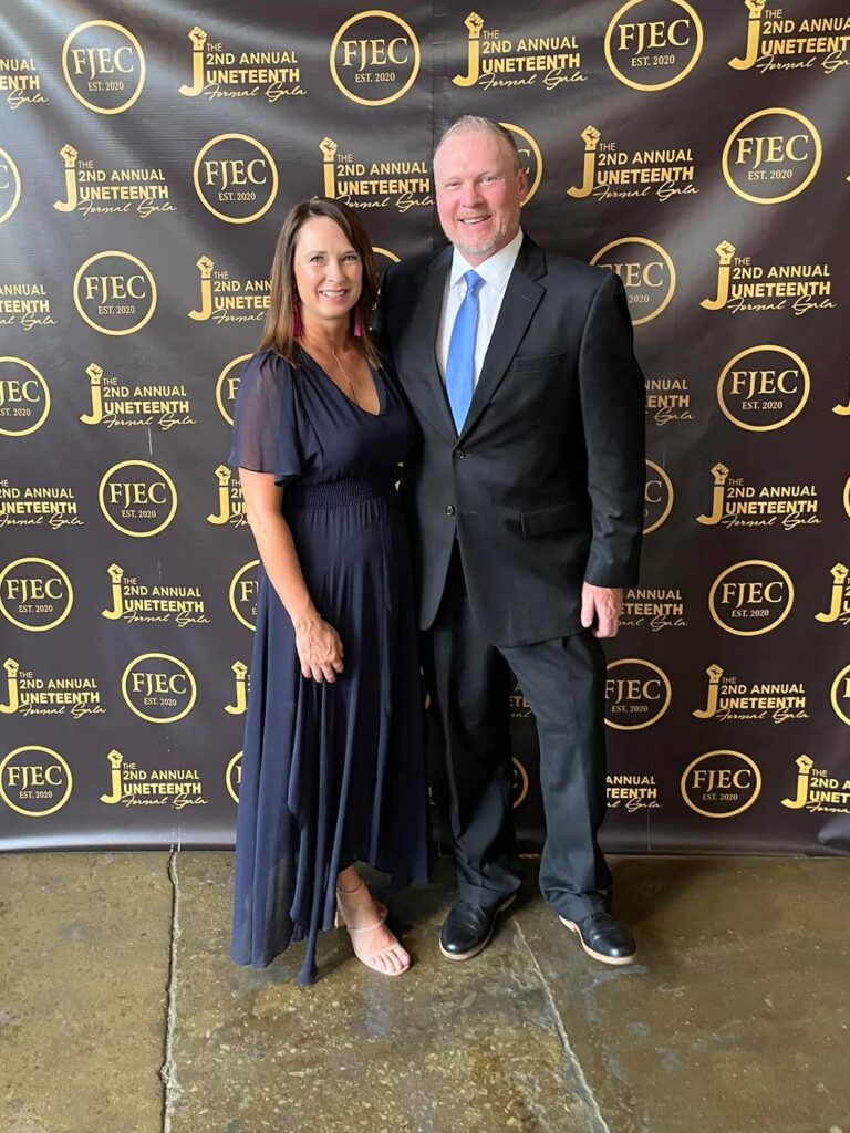 Annette and Rob Doom pose in front of a step-and-repeat wall at Franklin Justice and Equity Coalition's Juneteenth Gala in 2022.