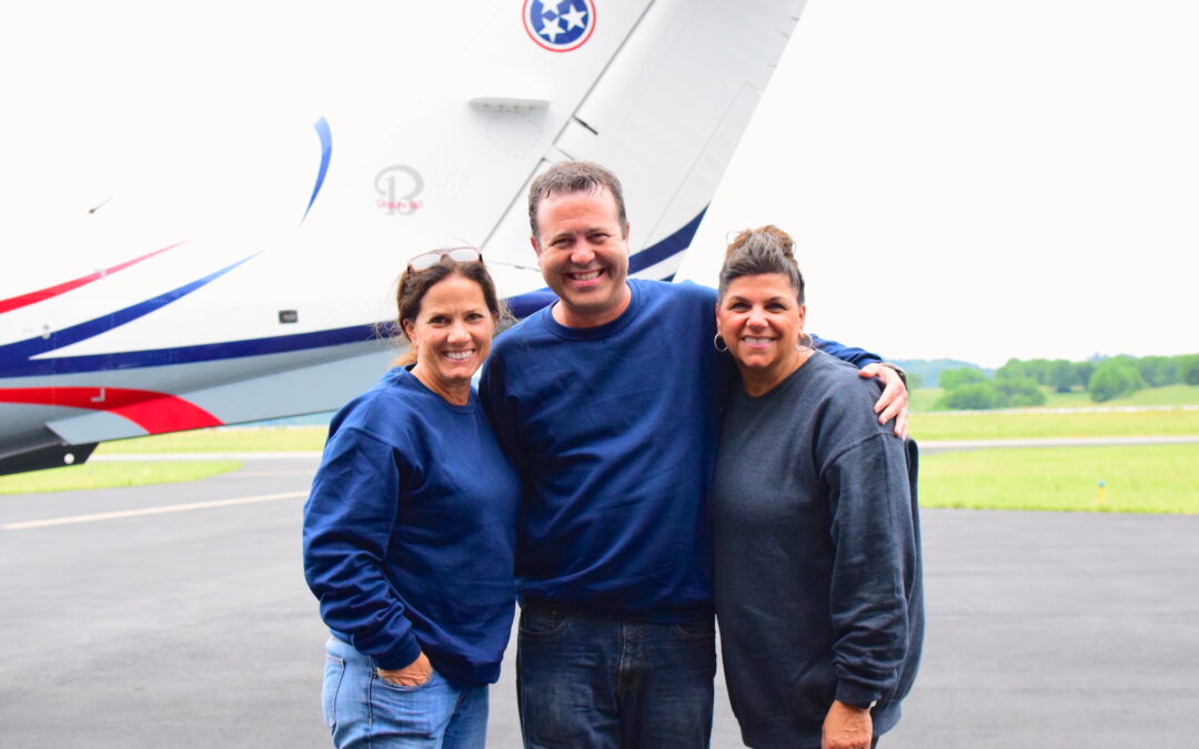 Maria Lee, Scott Lucas, and Elaine Whitney stand in front of a Tennessee state plane